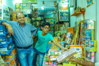 A fire cracker seller gleefully poses with his son during Diwali season. "This is the main season when we earn the most. Even foreigners buy our crackers these days says Rangarajan"